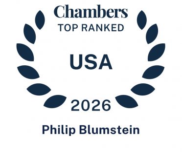 Dark blue icon in the shape of a laurel wreath that says Chambers Ranked In USA 2026 Phil Blumstein.