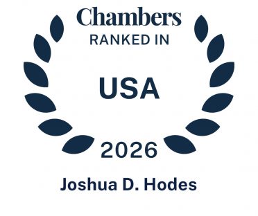 Dark blue icon in the shape of a laurel wreath that says Chambers Ranked In USA 2026 Joshua D. Hodes.