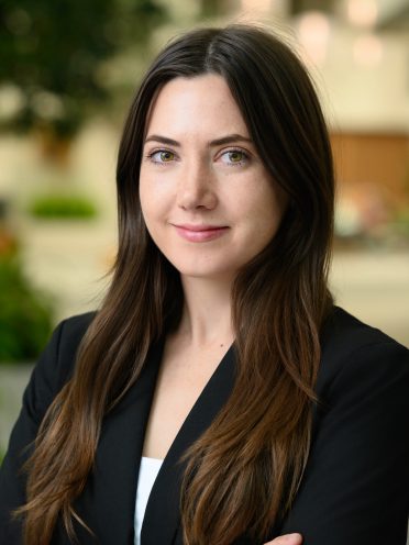 Kyla Lucey is wearing a black blazer and has long brown hair.